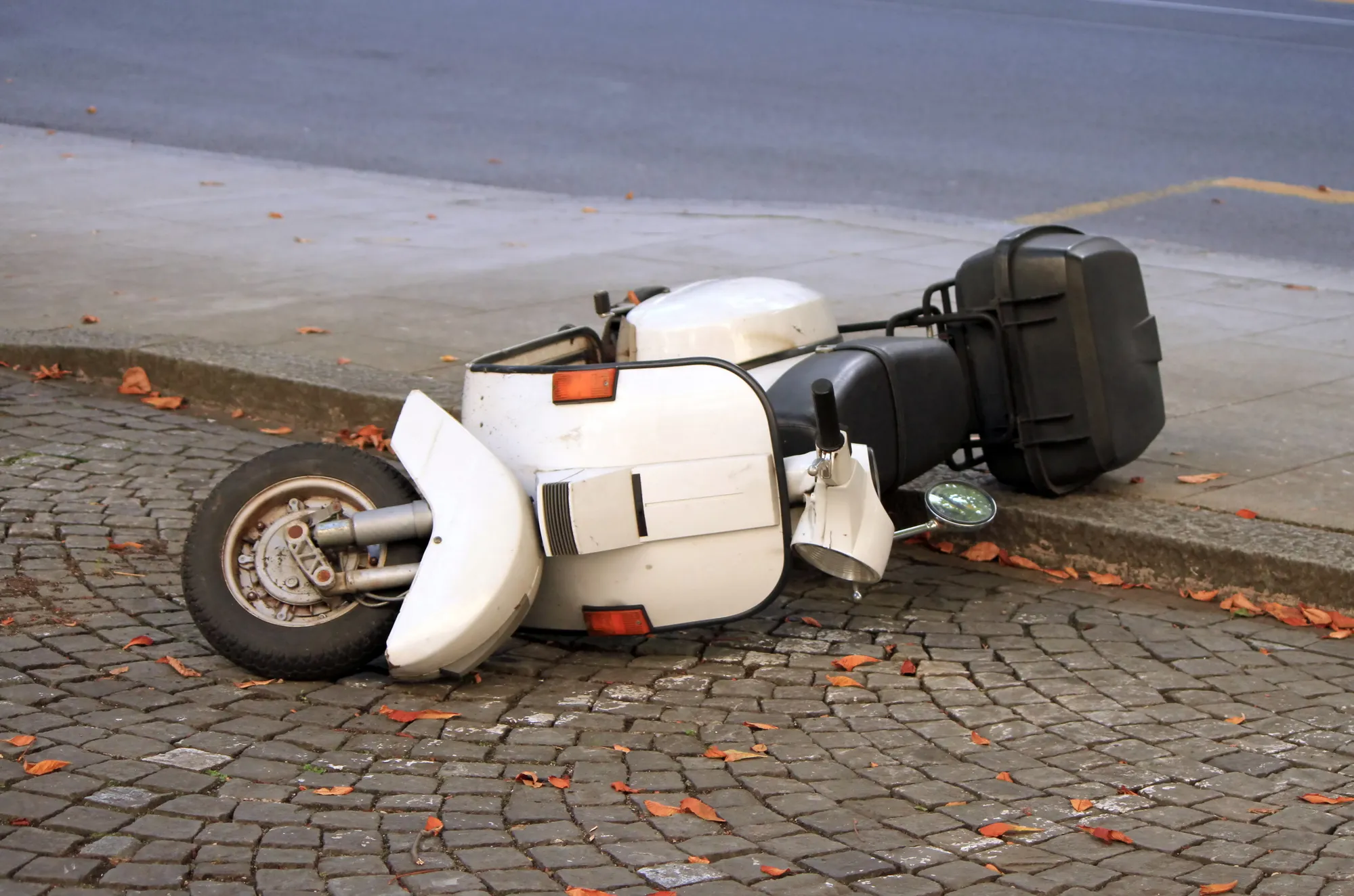 Image of a moped on its side in road, possibly part of a scam